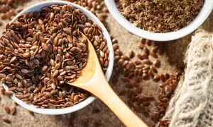 Schüssel mit ganzen Leinsamen und gemahlenen Leinsamen. Leinsamen roh essen ist gesund!