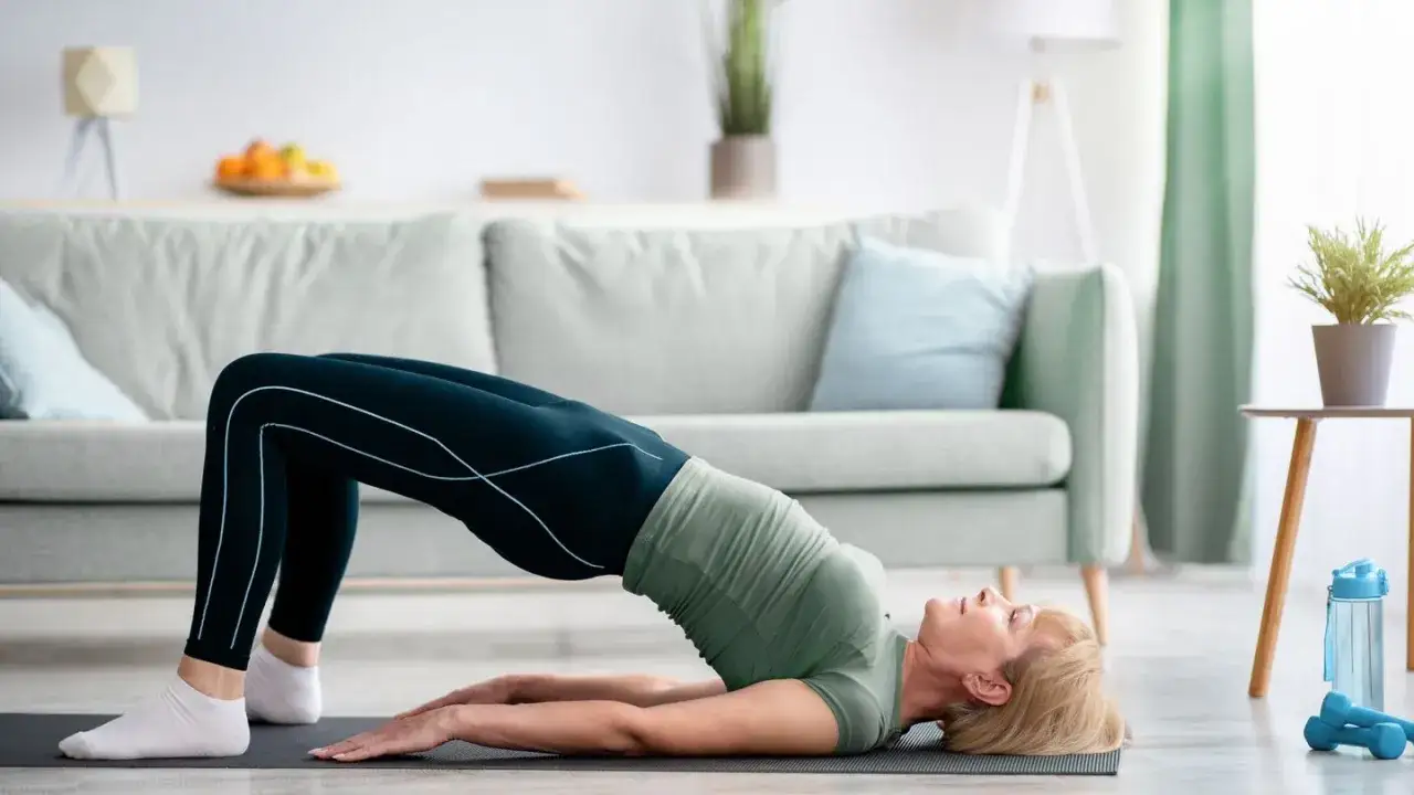 Frau macht eine Brücke auf einer Matte, eine Übung, die als Wunderwaffe gegen Arthrose gilt.